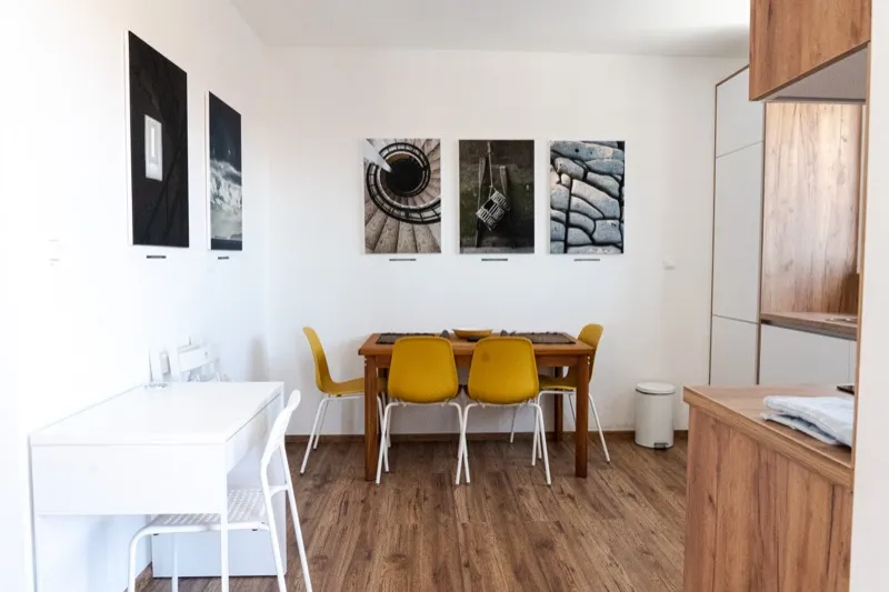 Dining area with yellow chairs and the kitchen